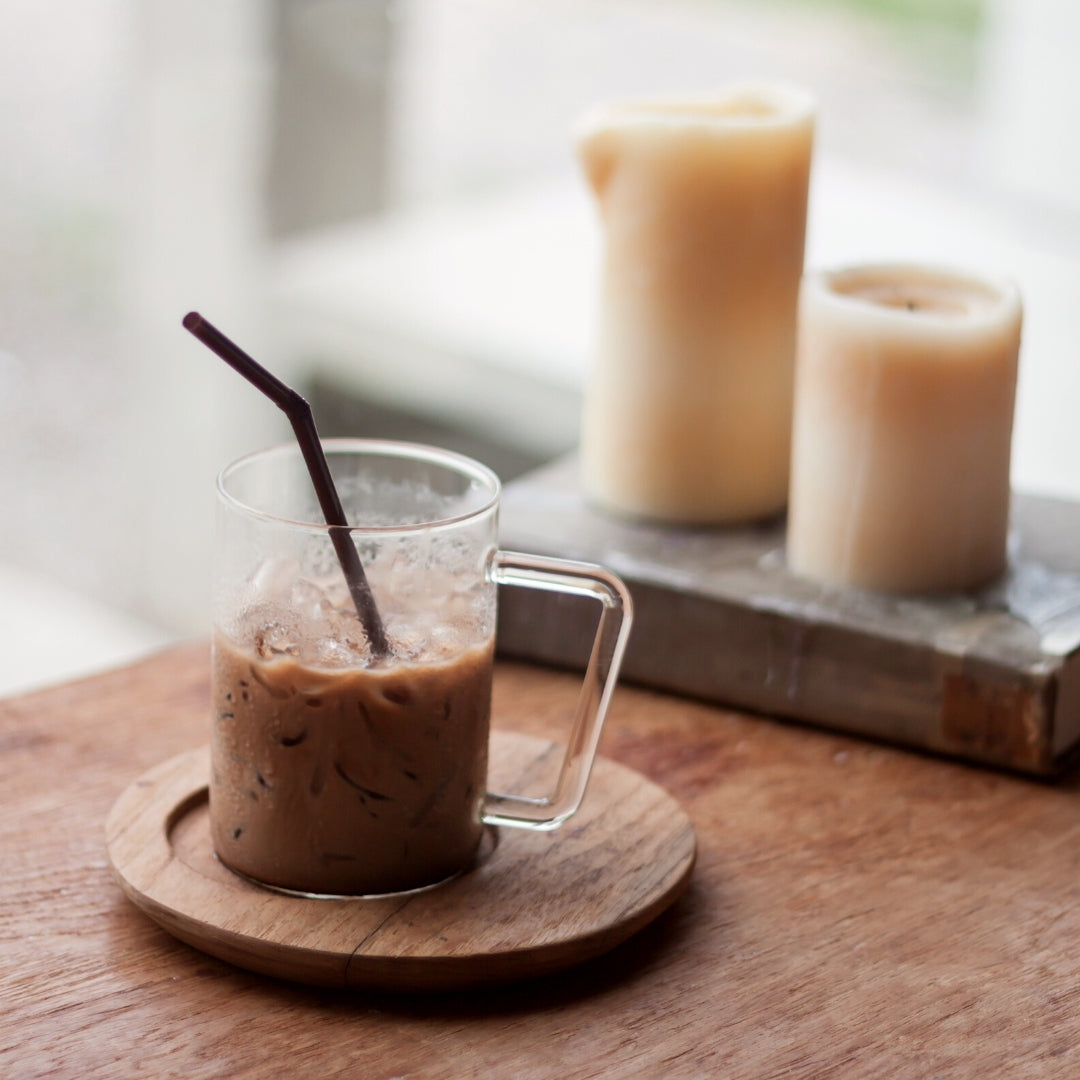 iced latte in glass cup, candles, wood