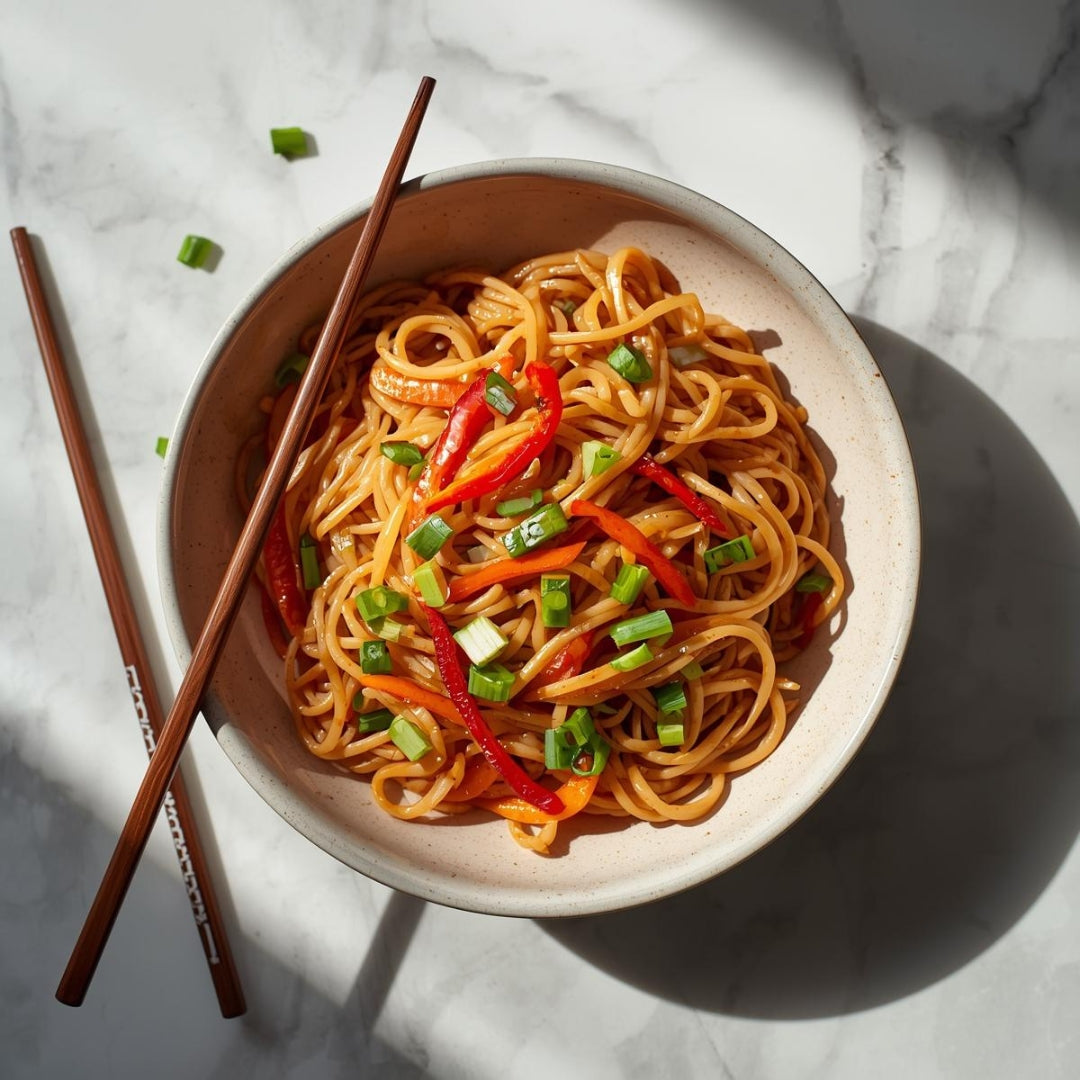 nouilles asiatiques dans une bol avec baguettes de bois sur comptoir de marbre